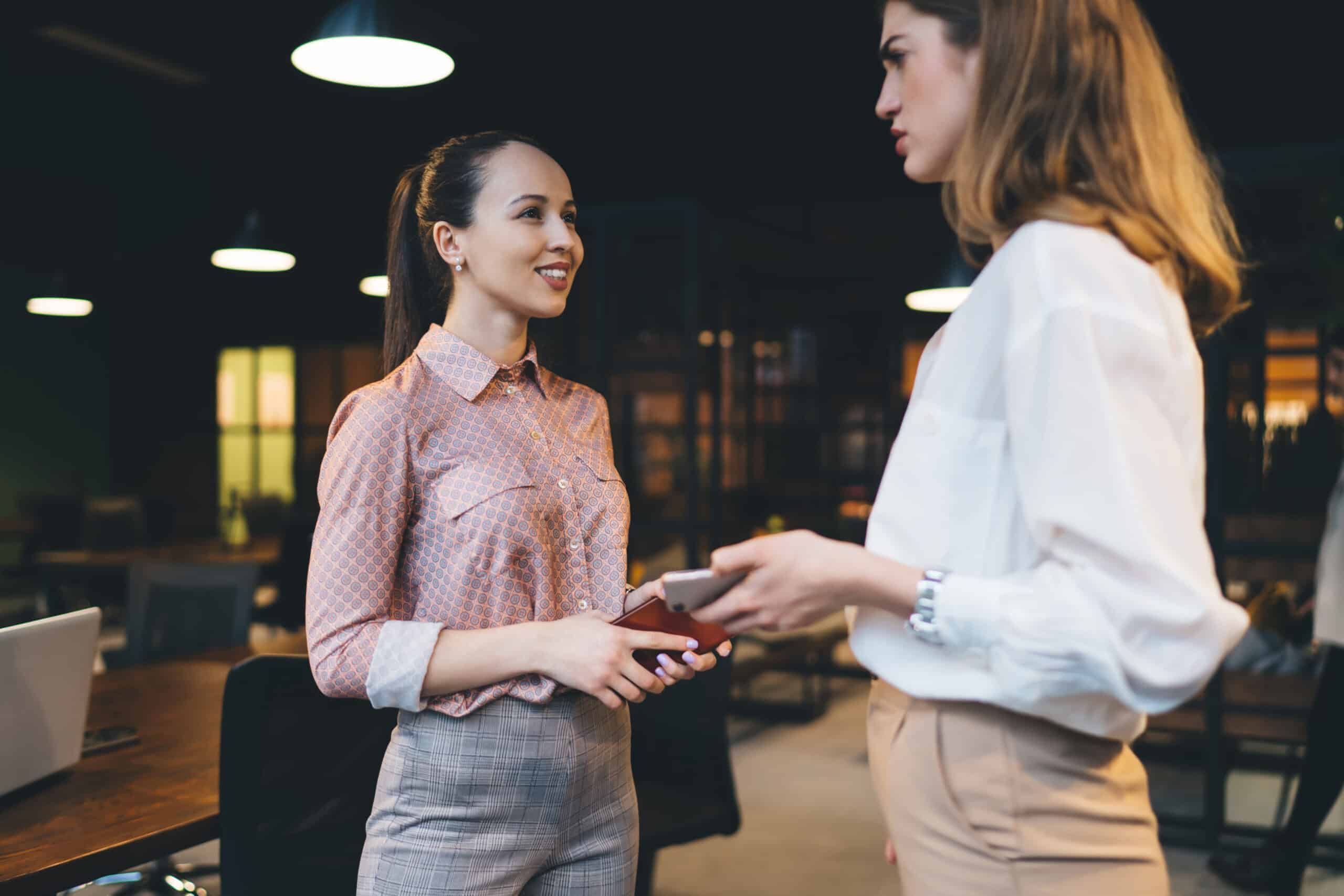 Pensive female coach supervising new employee in office